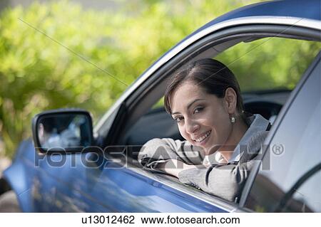 Stock Image - Woman in suit looking out car window. Fotosearch