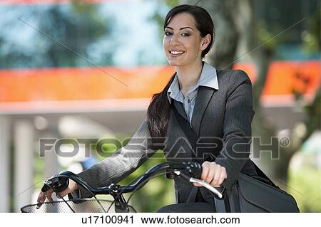 Stock Image - Woman in suit on bicycle. Fotosearch