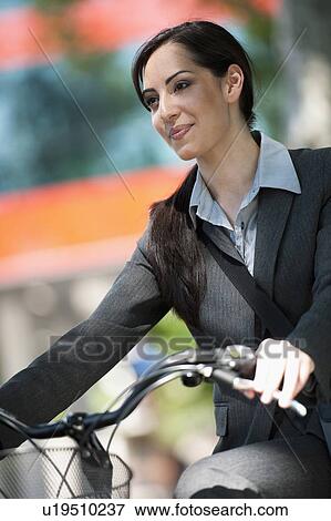 Woman in suit on bicycle View Large Photo Image Stock Photo - Woman in suit on bicycle. Fotosearch