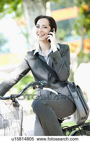 Woman in suit on bicycle talking on cellphone View Large Photo Image Stock Photography - Woman in suit on bicycle talking on cellphone. Fotosearch