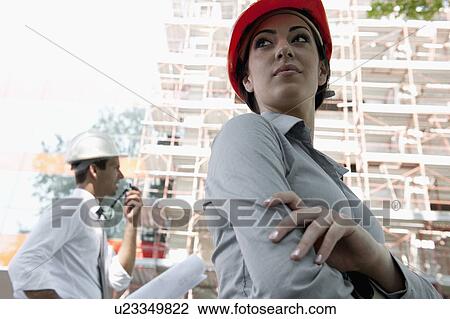 Woman with hardhat and man on walky talky at construction site View Large Photo Image Stock Image - Woman with hardhat and man on walky talky at construction site. Fotosearch