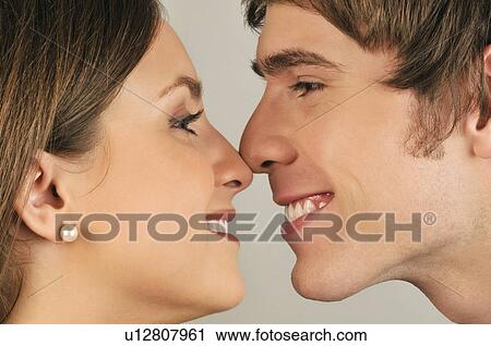 Stock Image - Young adult couple touching noses. Fotosearch