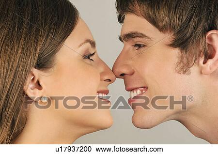 Stock Image - Young adult couple touching noses. Fotosearch