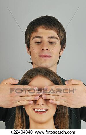Young adult male holding hands over woman's eyes View Large Photo Image Stock Image - Young adult male holding hands over woman's eyes. Fotosearch