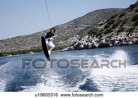 Stock Photograph - Young adult male waterskiing. Fotosearch
