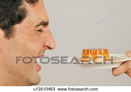 Stock Image - Young male adult being offered a dessert. Fotosearch