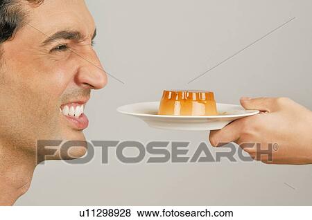 Stock Photo - Young male adult being offered a dessert. Fotosearch