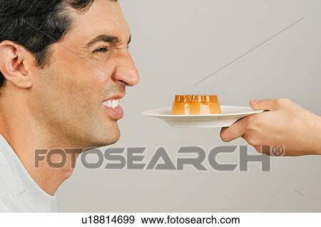 Young male adult being offered a dessert View Large Photo Image Stock Photo - Young male adult being offered a dessert. Fotosearch