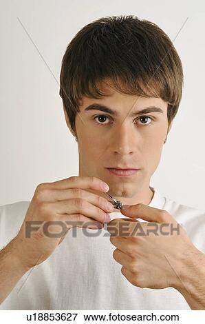 Young male adult cutting finger nails View Large Photo Image Stock Photo - Young male adult cutting finger nails. Fotosearch