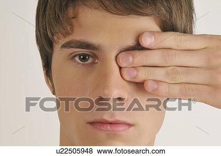 Young male adult; hand covering one eye View Large Photo Image Stock Photo - Young male adult; hand covering one eye. Fotosearch