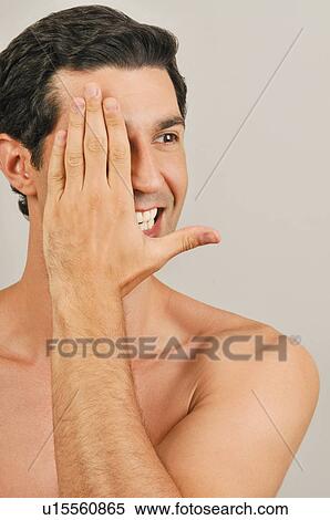 Stock Photography - Young male adult; hand covering one eye. Fotosearch