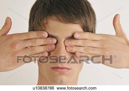 Stock Photograph - Young male adult; hands covering eyes. Fotosearch