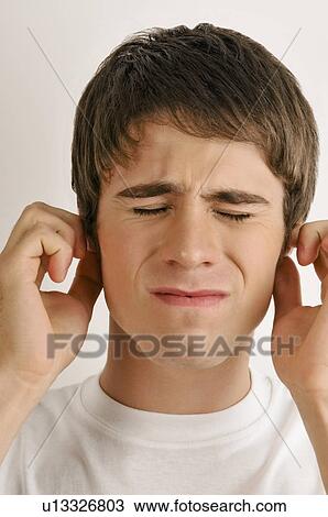 Stock Image - Young male adult holding ears. Fotosearch