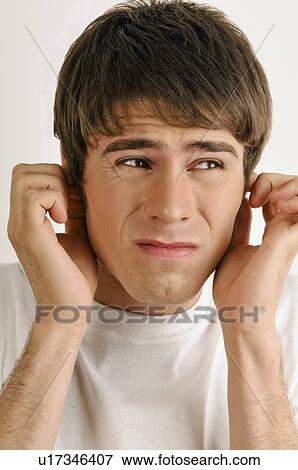 Stock Photo - Young male adult holding ears. Fotosearch