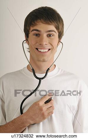 Young male adult; listening to his heart with stethoscope View Large Photo Image Stock Image - Young male adult; listening to his heart with stethoscope. Fotosearch