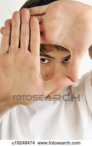 Young male adult; looking through hands View Large Photo Image Picture - Young male adult; looking through hands. Fotosearch