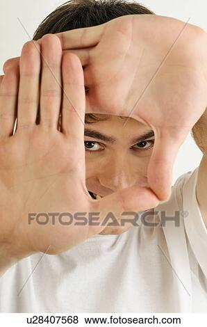 Young male adult; looking through hands View Large Photo Image Stock Photo - Young male adult; looking through hands. Fotosearch