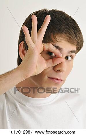 Young male adult; looking through fingers' hole View Large Photo Image Stock Photo - Young male adult; looking through fingers' hole. Fotosearch