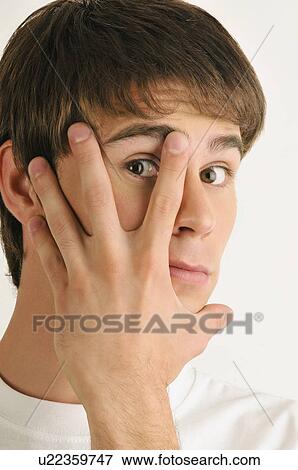 Young male adult; looking through fingers View Large Photo Image Stock Photo - Young male adult; looking through fingers. Fotosearch