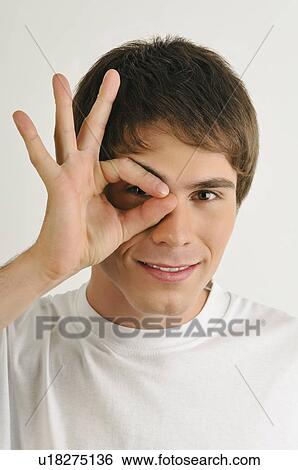 Young male adult; looking through fingers' hole View Large Photo Image Stock Photograph - Young male adult; looking through fingers' hole. Fotosearch
