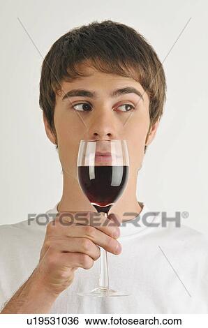 Stock Photograph - Young male adult smelling a glass of red wine. Fotosearch