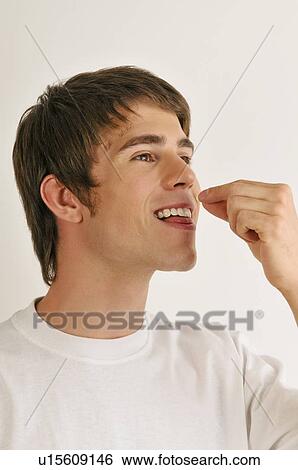 Stock Photograph - Young male adult tasting with hands. Fotosearch