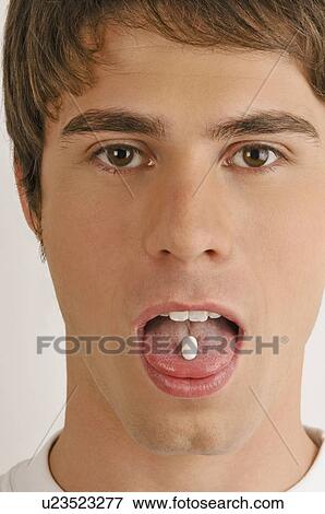 Young male adult with pill on tongue View Large Photo Image Stock Photo - Young male adult with pill on tongue. Fotosearch