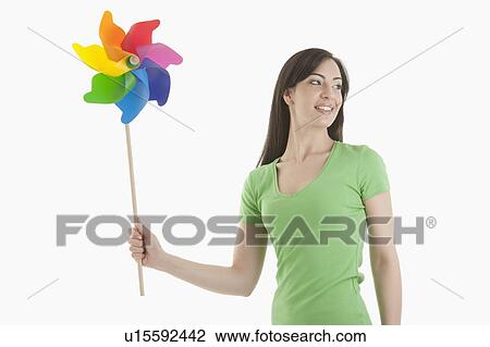 Young woman holding pinwheel View Large Photo Image Stock Image - Young woman holding pinwheel. Fotosearch
