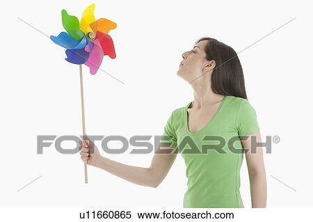 Young woman holding pinwheel View Large Photo Image Stock Photography - Young woman holding pinwheel. Fotosearch