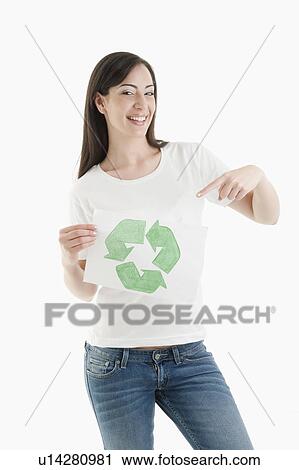 Stock Image - Young woman holding recycling symbol drawing. Fotosearch