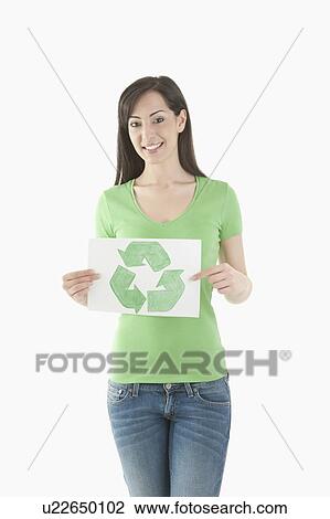 Stock Image - Young woman holding recycling symbol drawing. Fotosearch