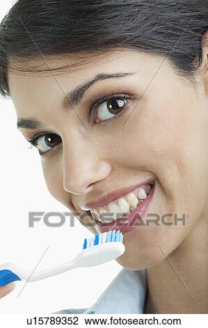 Stock Image - Young woman holding toothbrush. Fotosearch