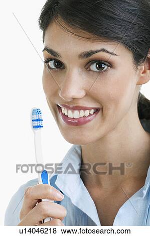 Young woman holding toothbrush View Large Photo Image Stock Photo - Young woman holding toothbrush. Fotosearch