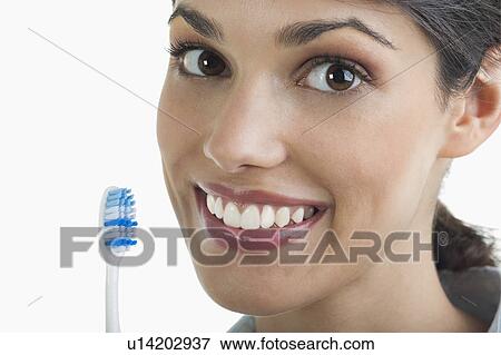 Stock Photo - Young woman holding toothbrush. Fotosearch
