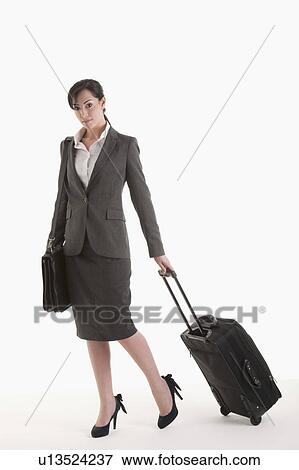 Young woman in suit with wheeled suitcase View Large Photo Image Stock Photo - Young woman in suit with wheeled suitcase. Fotosearch