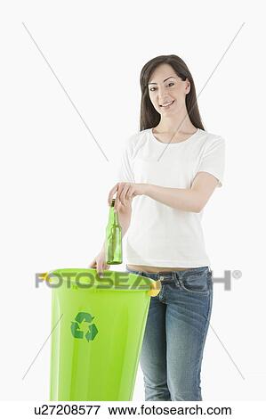 Young woman throwing glass bottle in the recycling bin View Large Photo Image Stock Photo - Young woman throwing glass bottle in the recycling bin. Fotosearch