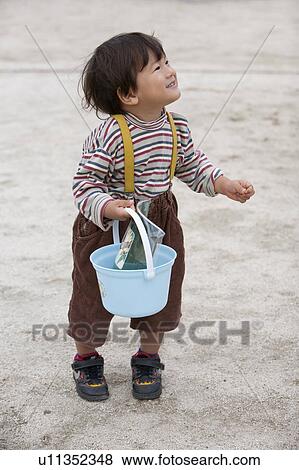 Stock Photo - 2-year Old Boy Holding Bucket. Fotosearch