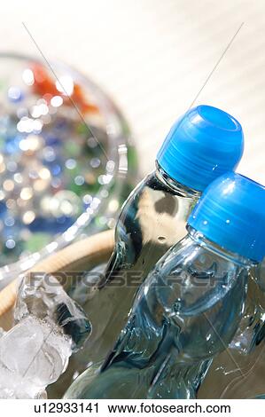 Stock Image - Bottle of sodas in bucket full of ice. Fotosearch