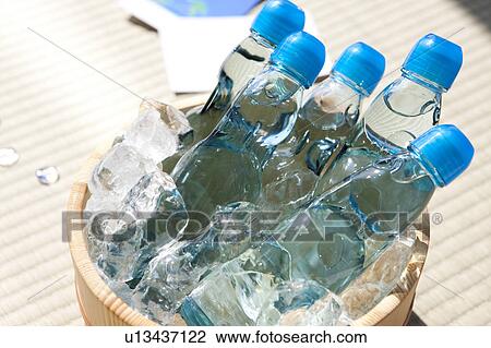 Stock Image - Bottle of sodas in bucket full of ice. Fotosearch