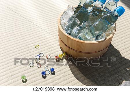 Stock Photo - Bottle of sodas in bucket full of ice and marbles on tatami. Fotosearch