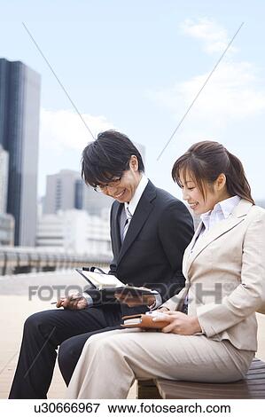 Stock Photo - Business Colleagues Looking at Diary. Fotosearch