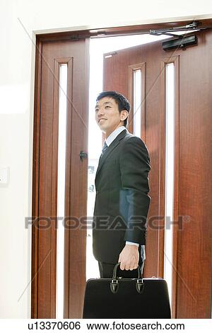 Stock Photograph - Businessman leaving home to work, Hyogo Prefecture, Honshu, Japan. Fotosearch