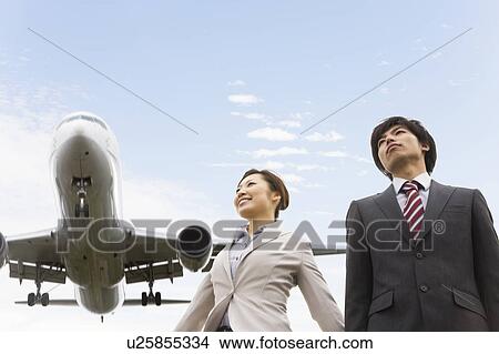 Picture - Businesspeople Below Airplane. Fotosearch