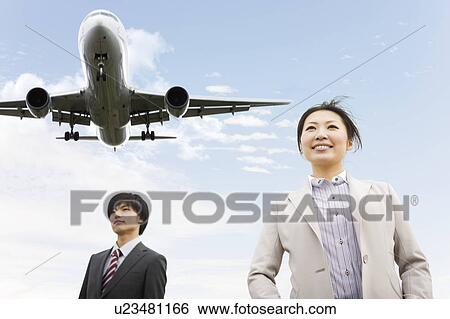 Stock Photograph - Businesspeople Below Airplane. Fotosearch