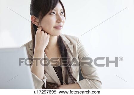Stock Photography - Businesswoman at her desk contemplating. Fotosearch