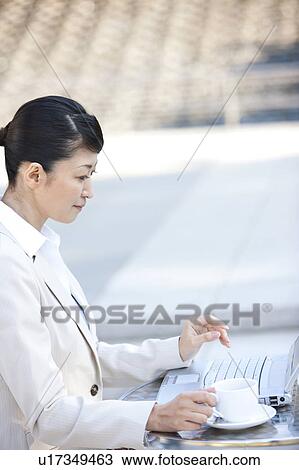 Businesswoman drinking coffee and using laptop View Large Photo Image Stock Image - Businesswoman drinking coffee and using laptop. Fotosearch