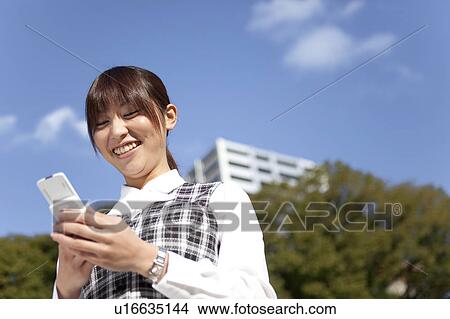 Businesswoman holding a cell phone View Large Photo Image Picture - Businesswoman holding a cell phone. Fotosearch