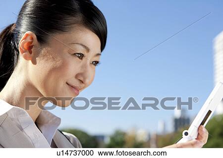 Businesswoman holding a cell phone View Large Photo Image Stock Image - Businesswoman holding a cell phone. Fotosearch