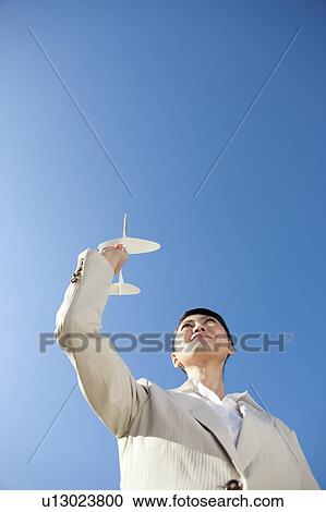 Stock Image - Businesswoman holding a paper airplane. Fotosearch