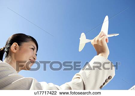 Businesswoman holding a paper airplane View Large Photo Image Stock Image - Businesswoman holding a paper airplane. Fotosearch